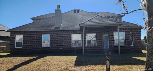 rear view of property with a lawn