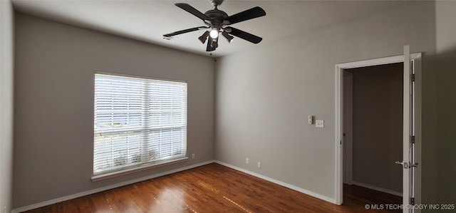 empty room featuring dark wood-type flooring, a wealth of natural light, and ceiling fan