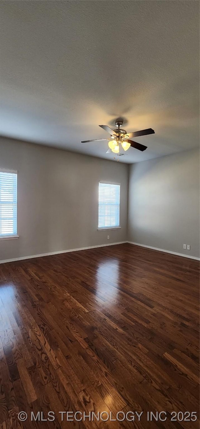 spare room with dark wood-type flooring, ceiling fan, and a textured ceiling