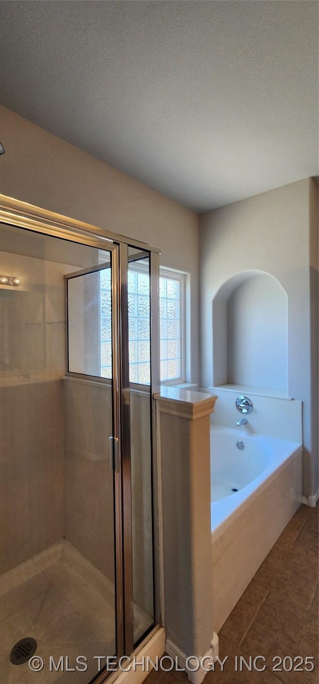 bathroom with plus walk in shower and a textured ceiling