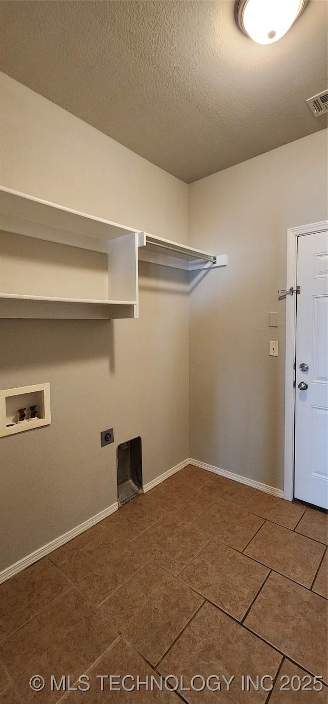 laundry room with tile patterned flooring, hookup for a washing machine, a textured ceiling, and electric dryer hookup