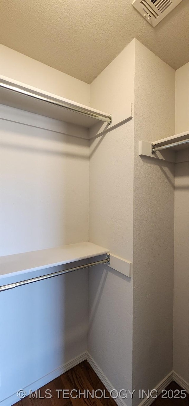 spacious closet featuring dark hardwood / wood-style flooring