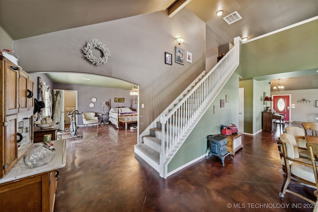 stairway featuring ceiling fan with notable chandelier, concrete flooring, high vaulted ceiling, and beam ceiling