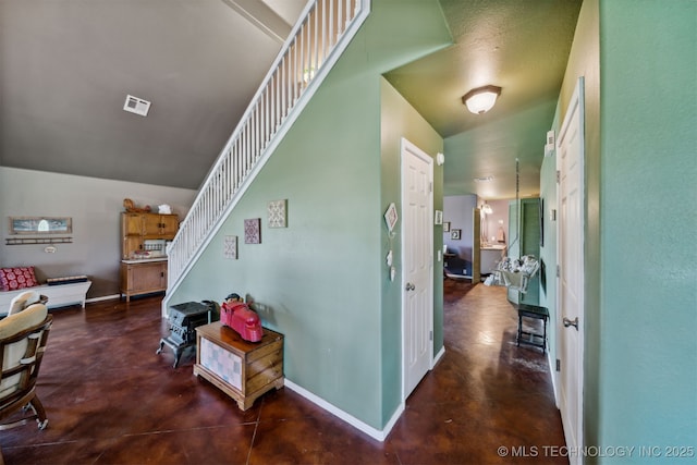 staircase featuring concrete flooring and vaulted ceiling