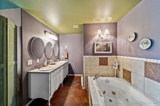 bathroom with tile patterned flooring, a bathing tub, vanity, and a textured ceiling