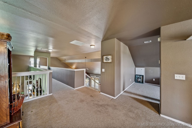 bonus room with vaulted ceiling, light carpet, and a textured ceiling