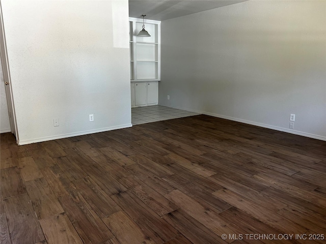 unfurnished room with dark hardwood / wood-style flooring