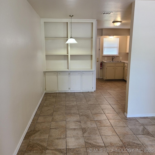 unfurnished dining area featuring light tile patterned floors and sink