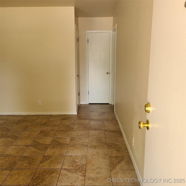 hall featuring dark tile patterned flooring