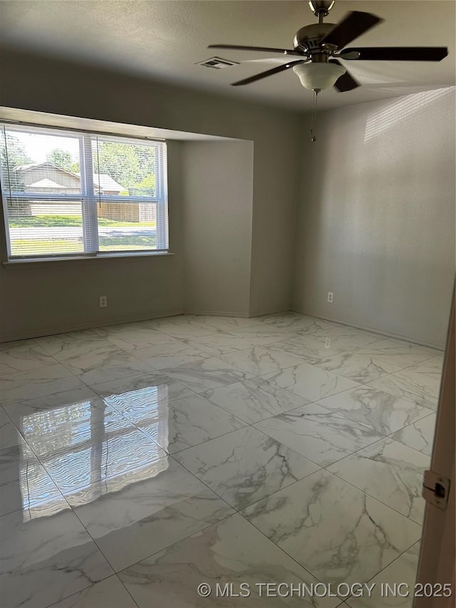 spare room featuring a textured ceiling and ceiling fan