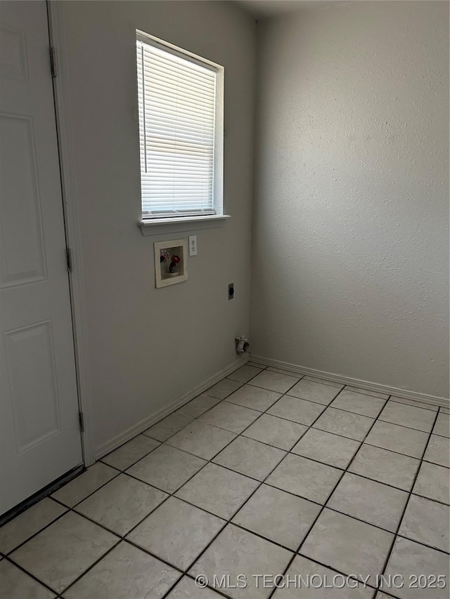 clothes washing area featuring hookup for a washing machine and light tile patterned floors