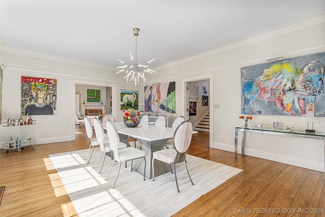 dining area featuring a notable chandelier, hardwood / wood-style flooring, and ornamental molding