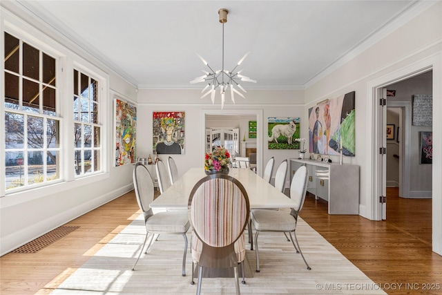 dining room featuring ornamental molding, a chandelier, and wood-type flooring