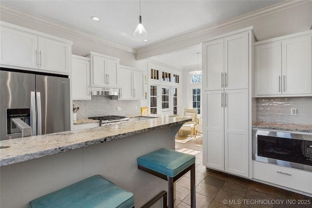 kitchen with white cabinets, a kitchen breakfast bar, hanging light fixtures, stainless steel refrigerator with ice dispenser, and light stone countertops