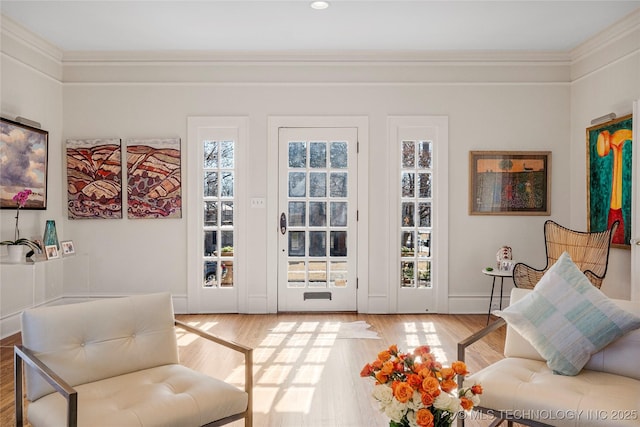 entryway featuring wood-type flooring and ornamental molding