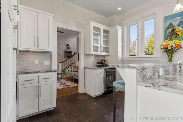 kitchen with white cabinetry, light stone countertops, and beverage cooler