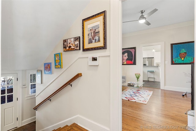 stairs with crown molding, ceiling fan, and wood-type flooring