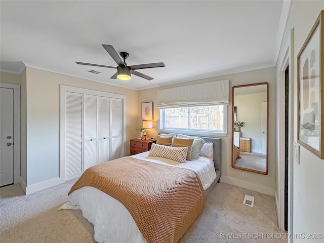 carpeted bedroom featuring crown molding, ceiling fan, and a closet