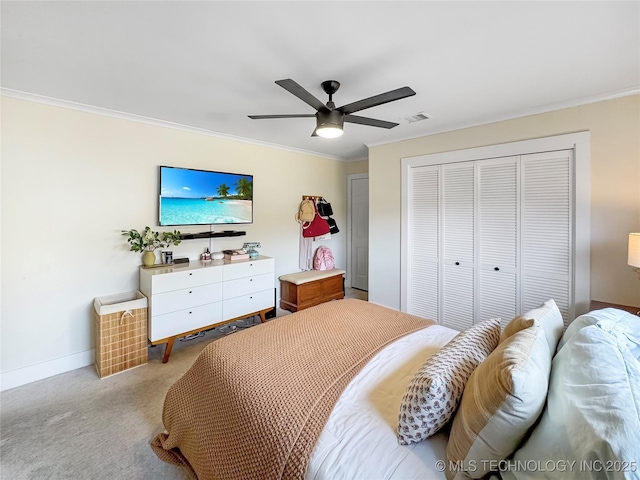 carpeted bedroom with ornamental molding, ceiling fan, and a closet