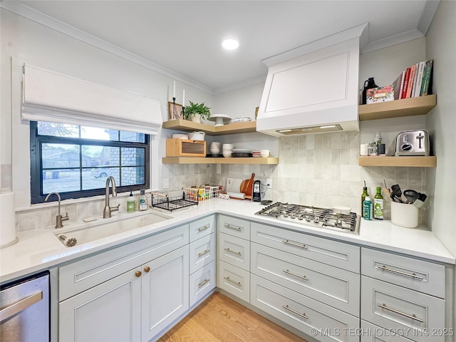 kitchen featuring stainless steel appliances, crown molding, sink, and backsplash