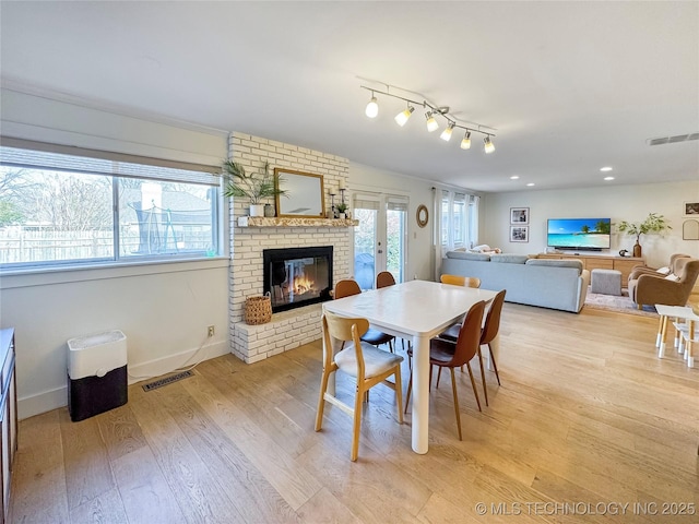 dining area featuring a fireplace and light hardwood / wood-style flooring