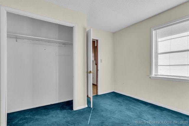 unfurnished bedroom featuring a closet, dark carpet, and a textured ceiling