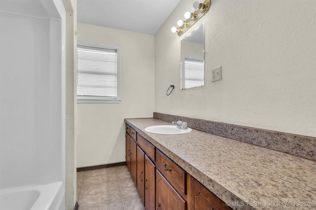 bathroom with vanity, a bath, and plenty of natural light