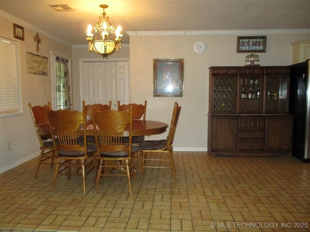 dining room with ornamental molding and an inviting chandelier