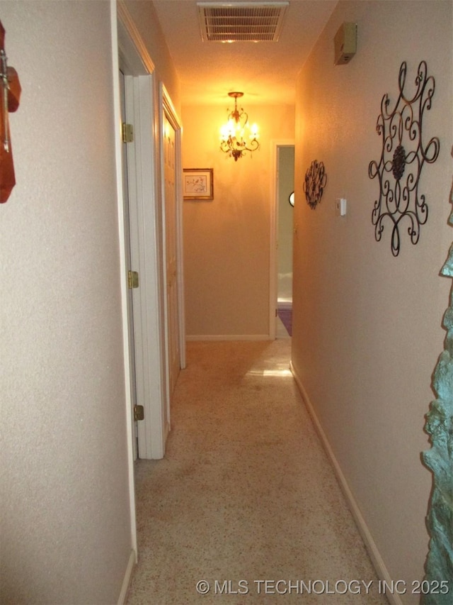 hallway featuring a chandelier