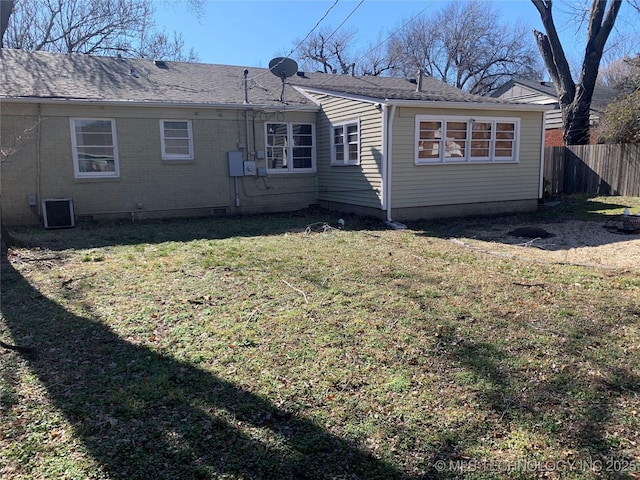 back of property featuring cooling unit and a lawn