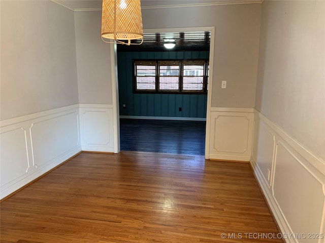 unfurnished room with dark hardwood / wood-style flooring, a notable chandelier, and crown molding