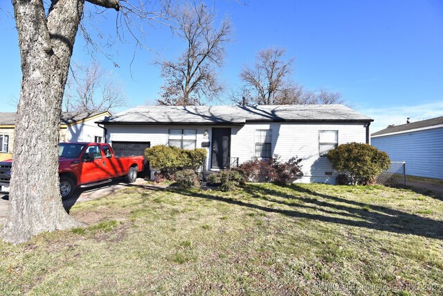 single story home with a garage and a front lawn