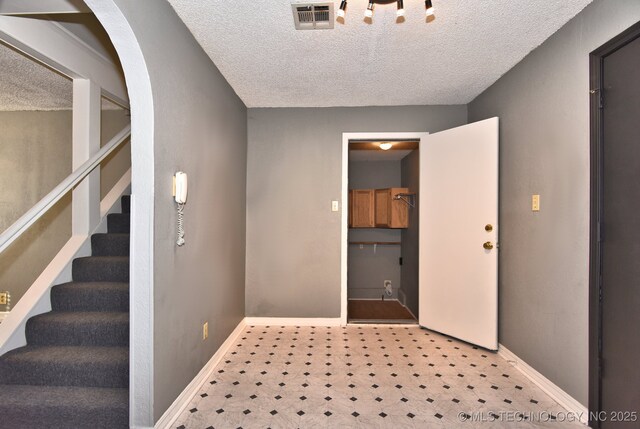 spare room with dark wood-type flooring, ornamental molding, and a textured ceiling