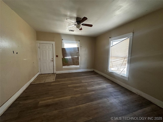 empty room with ceiling fan and dark hardwood / wood-style flooring