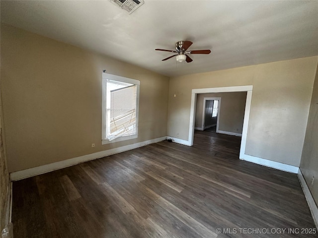 empty room with dark wood-type flooring, ceiling fan, and a wealth of natural light