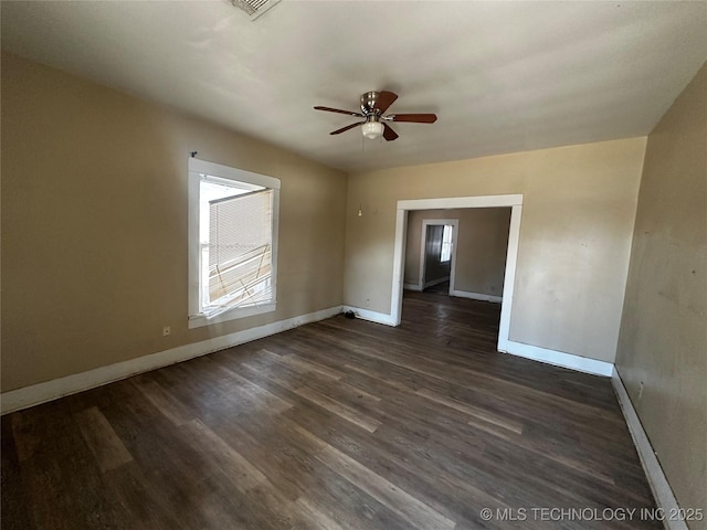 spare room featuring dark wood-type flooring and ceiling fan