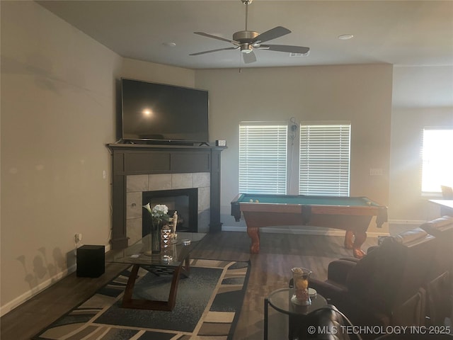 living room featuring pool table, ceiling fan, dark hardwood / wood-style floors, and a tile fireplace