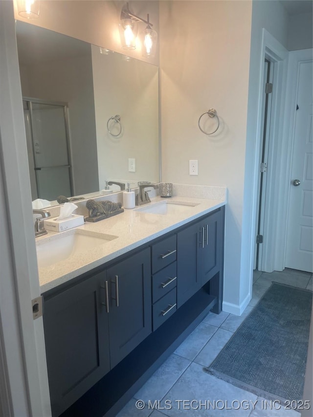 full bath with double vanity, tile patterned flooring, a shower with door, and a sink