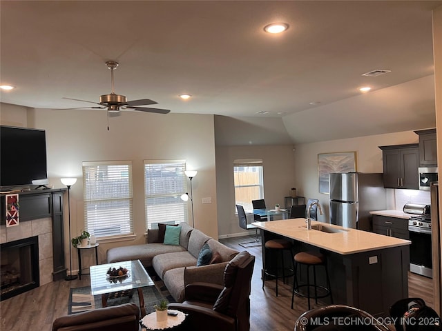 living room with visible vents, recessed lighting, a tile fireplace, and dark wood-style flooring