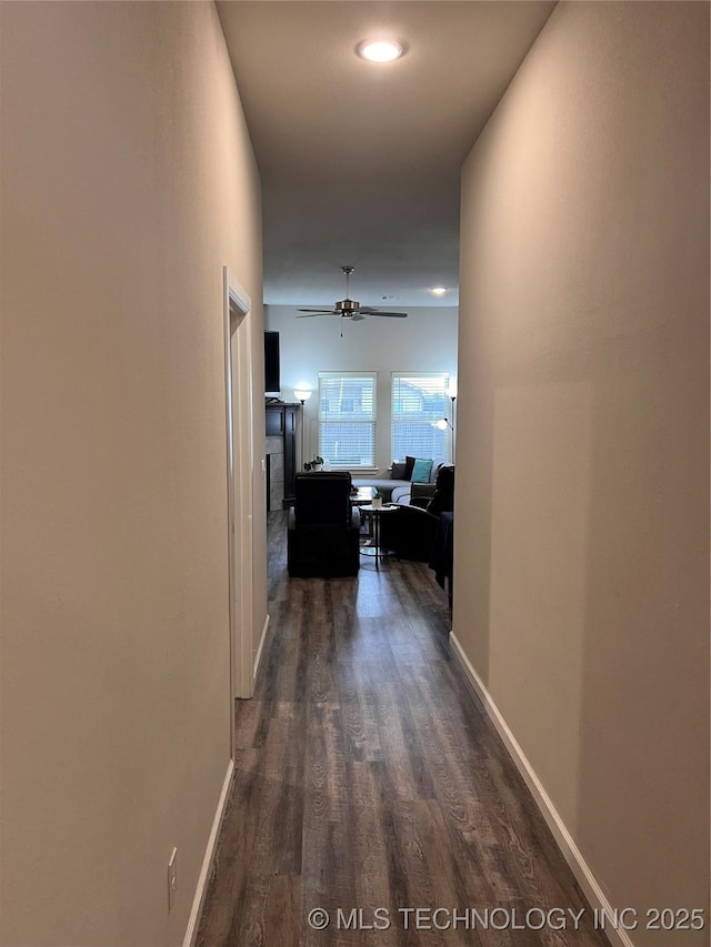 corridor featuring dark wood-style floors and baseboards