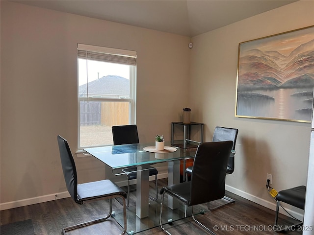 dining area with baseboards, wood finished floors, and vaulted ceiling