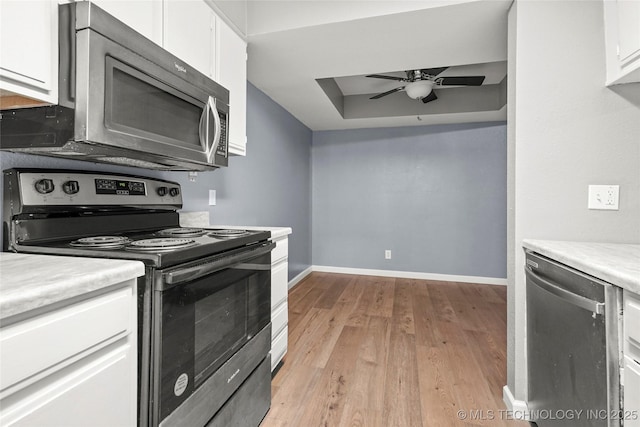 kitchen featuring ceiling fan, appliances with stainless steel finishes, light hardwood / wood-style floors, and white cabinets