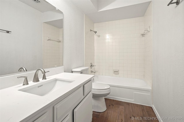 full bathroom with hardwood / wood-style flooring, vanity, toilet, and tiled shower / bath combo