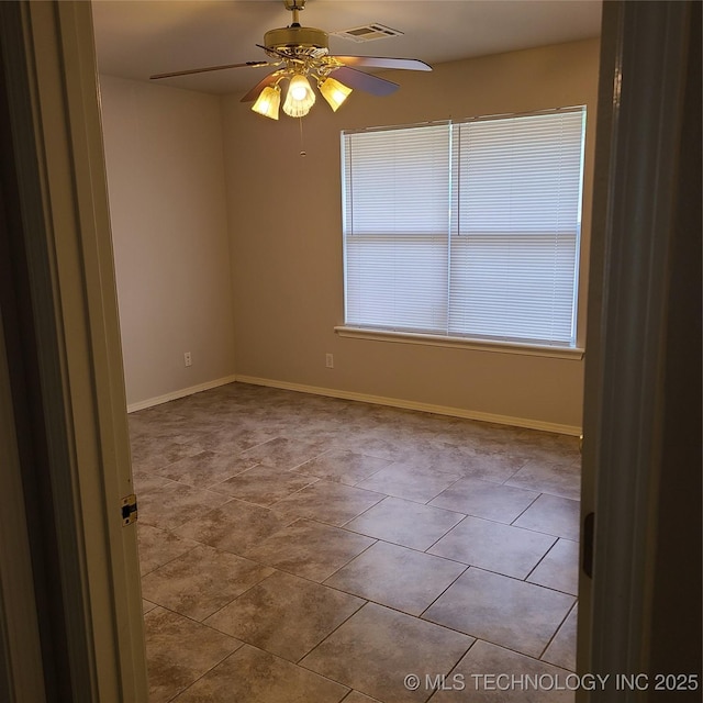 tiled empty room with ceiling fan