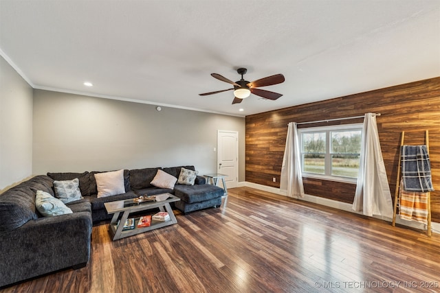 living room with wood-type flooring, crown molding, ceiling fan, and wooden walls