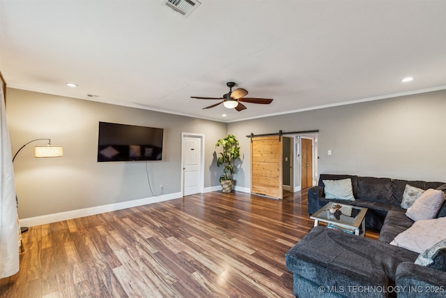 living room with ceiling fan, ornamental molding, wood-type flooring, and a barn door