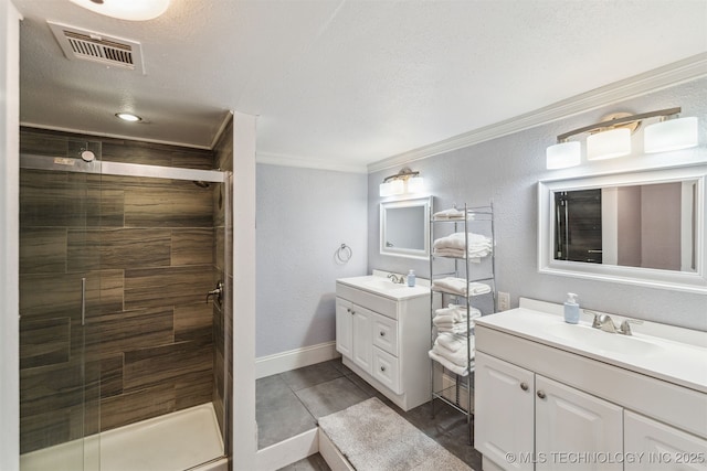 bathroom with vanity, crown molding, a shower with door, and a textured ceiling