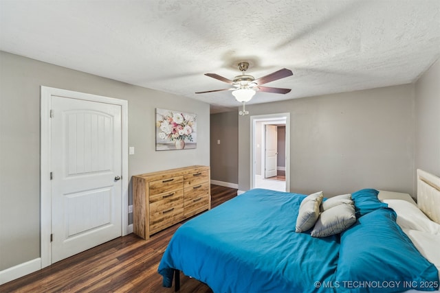 bedroom featuring ceiling fan, a textured ceiling, and dark hardwood / wood-style flooring