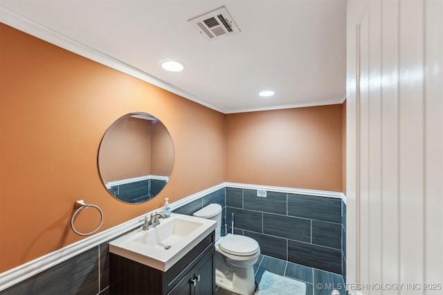 bathroom featuring crown molding, tile walls, vanity, and toilet