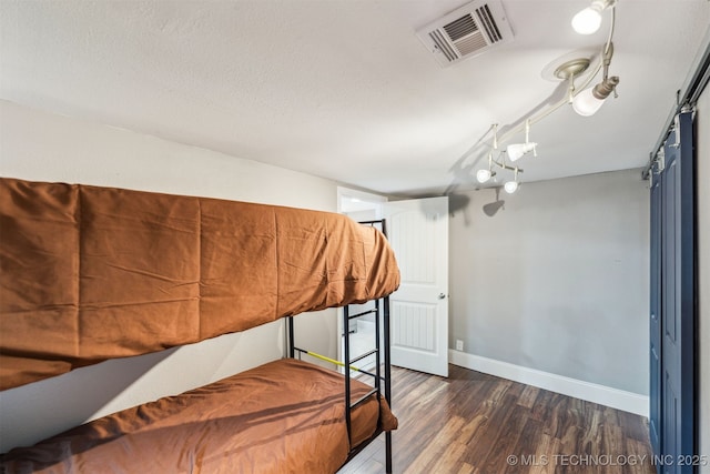 bedroom featuring a textured ceiling and dark hardwood / wood-style flooring